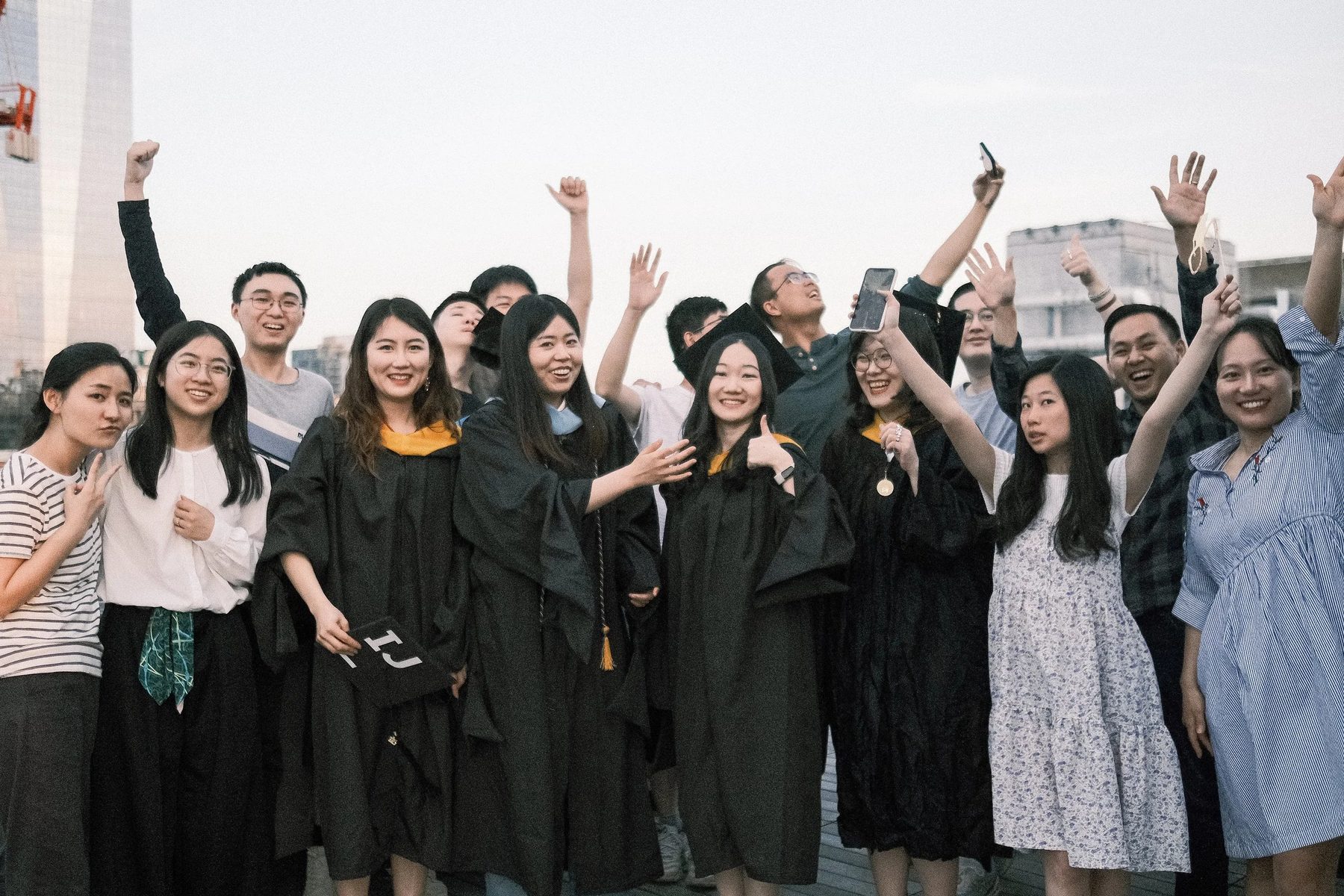 ISMP students celebrating at graduation, arms raised