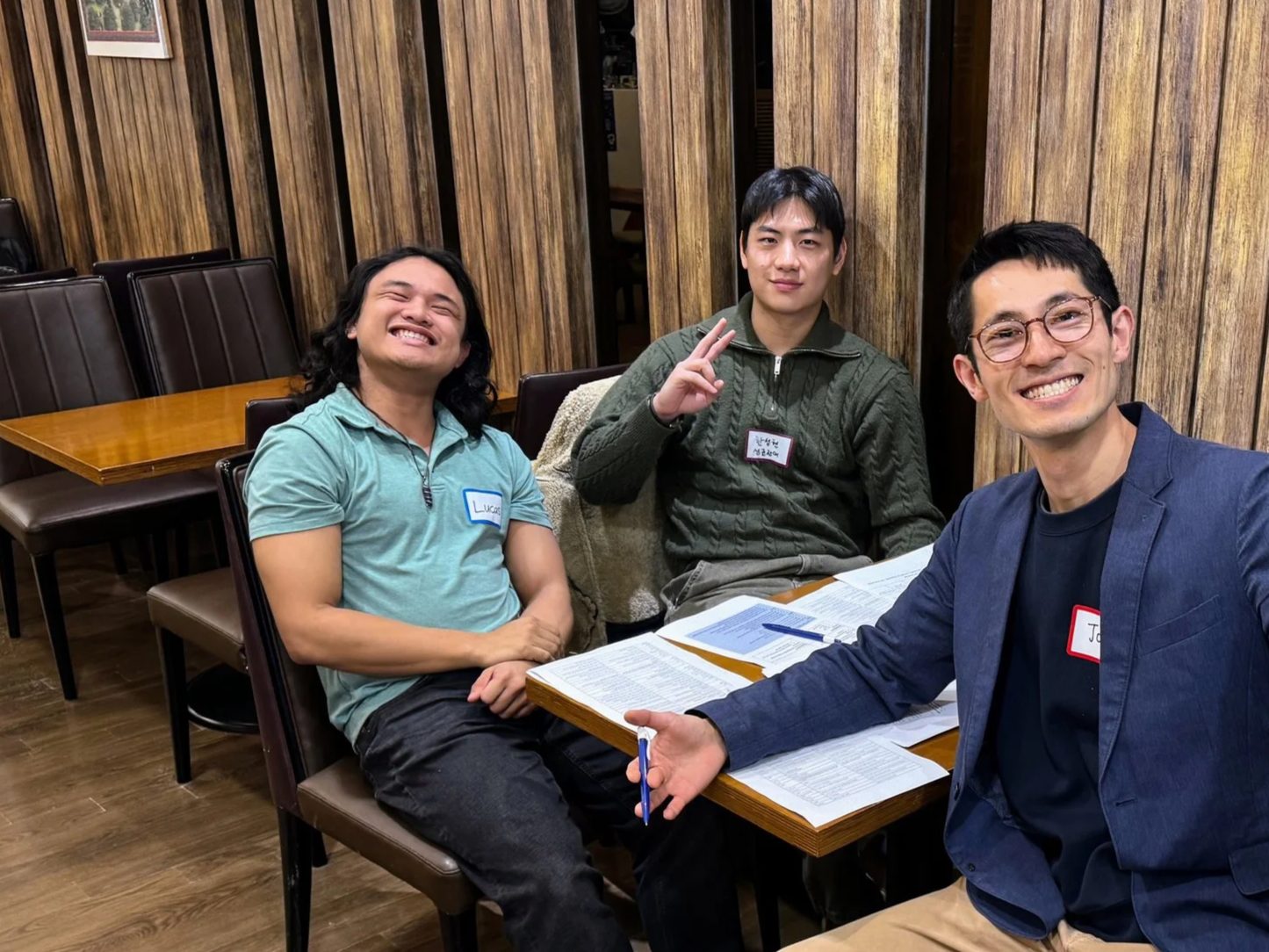 A mentor and two students talking and laughing around a table